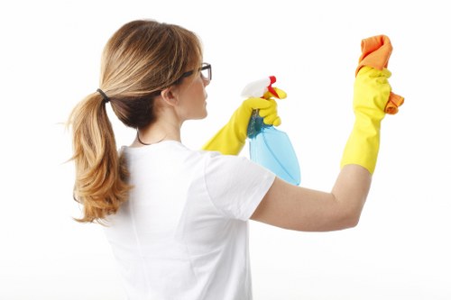 Professional cleaners sanitizing desks in an office in N4